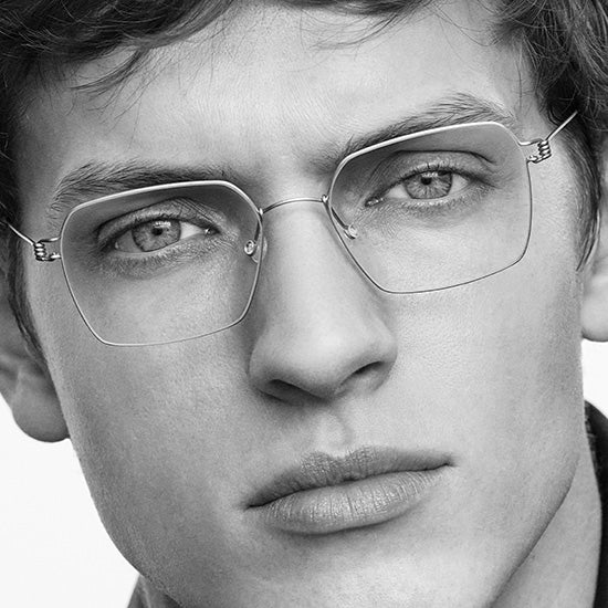 Giovane uomo che indossa occhiali Lindberg Air Titanium Rim, montatura leggera in titanio dal design minimalista.